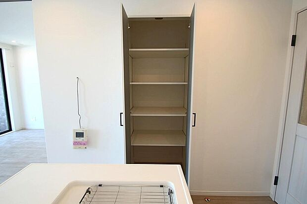 キッチン横の収納は棚が可動式のため掃除機などもしまえます