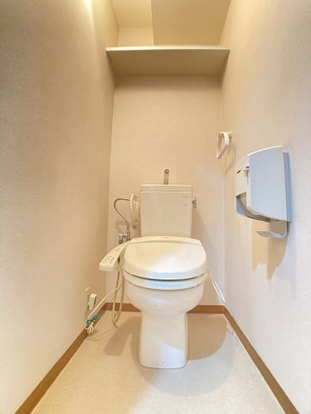 上部に収納棚のある温水洗浄機能付き暖房便座付のトイレです。