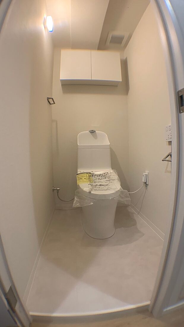 ホワイト基調の清潔感のあるトイレ空間となっています。温水便座機能付き♪タンク一体型のトイレ設計ですので、スリムでコンパクトな印象になっています。また、頭上の棚があるので、お掃除用具の収納もできますよ。