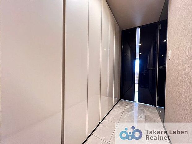 廊下には収納スペースを豊富に確保。床材にタイルを用いる事で高級感のある空間を演出します。