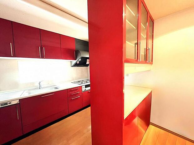 ※こちらの写真は、CGによる家具消し加工を行っておりますリビングのアクセントとなる赤基調のキッチン。キッチンのスペースが確保されており、カウンタータイプの食器棚付きです。