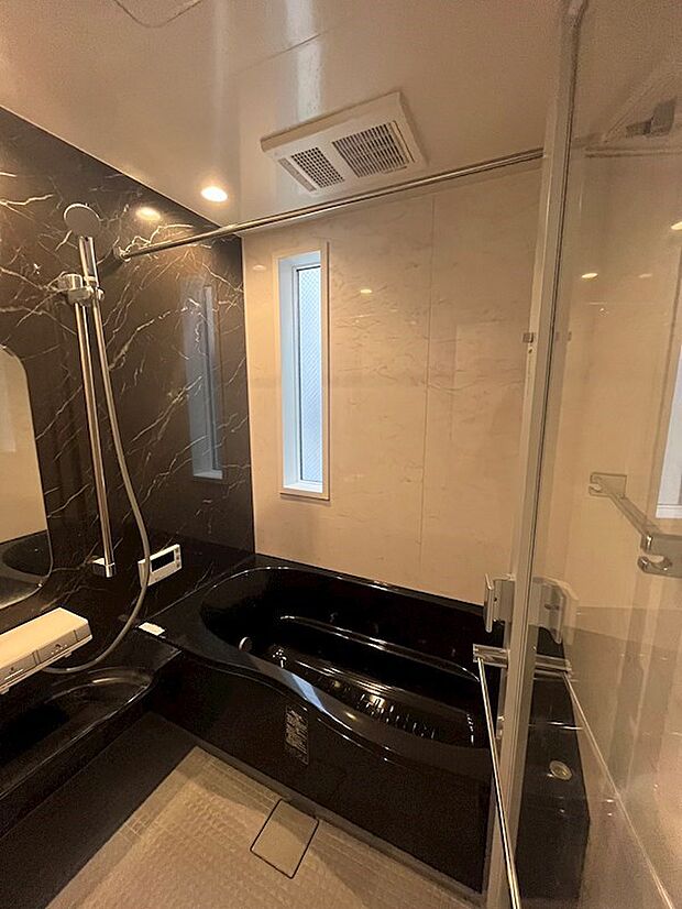 透明な扉が特徴的な浴室換気乾燥機付きの浴室。
