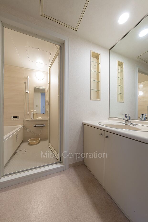 壁面一面に配置された大型の鏡付き洗面化粧台、脱衣スペースもゆったりしたスペースがございます。