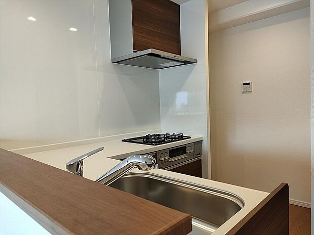 ガスコンロは余裕の３口、Ｌ字型キッチンは調理スペースが大きく取れるのが特長です。奥のスペースは冷蔵庫置き場