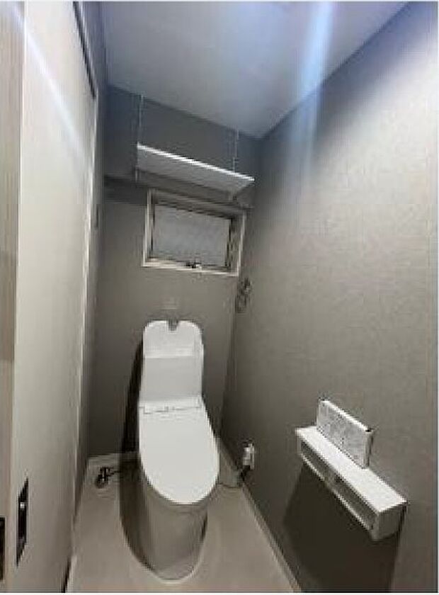 グレーの落ち着いたデザインのクロスを使用したトイレはおしゃれなイメージです。トイレ交換済みです。