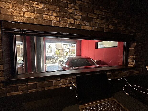 お仕事や勉強をしながらちょっとした休憩中に愛車を眺めることができるよう小窓を設けた書斎。