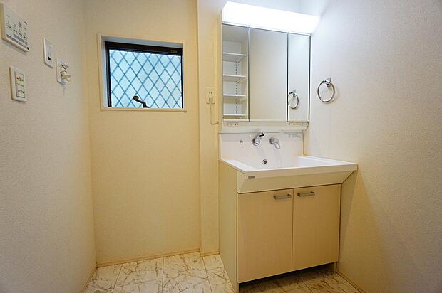 シャワー付き洗面台。洗面台向かい側にはタオルや洗剤などの小物が収納できる可動棚が設置。室内（2024年4月）撮影