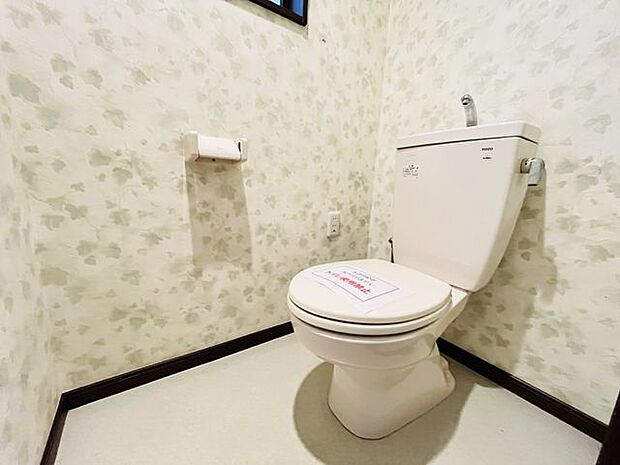 白を基調とした、清潔感のあるシンプルなデザインのトイレです。華やかに彩ってくれる花柄のクロスです。