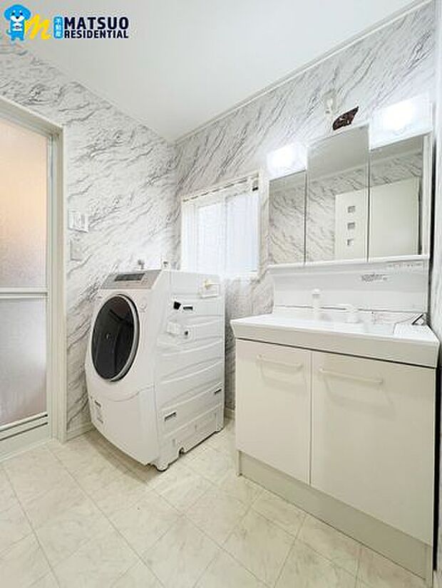 収納たっぷりの洗面台と洗濯機置場が並び、使いやすい洗面所です。