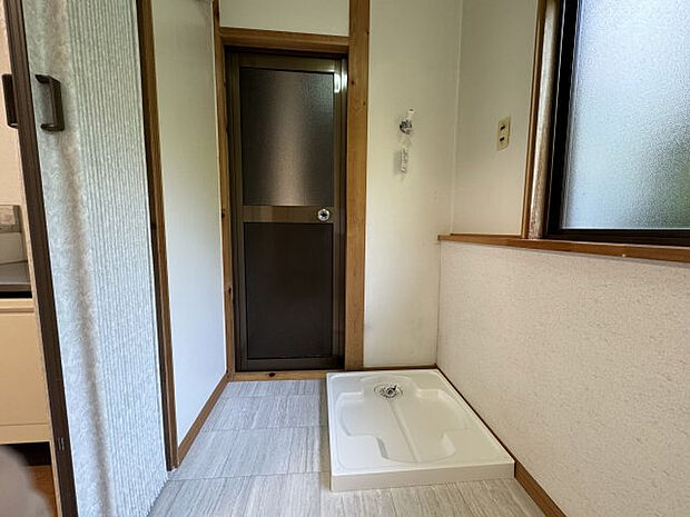 【ランドリースペース】室内洗濯機置場を新設しています。奥のドアは屋外の土間へのドア