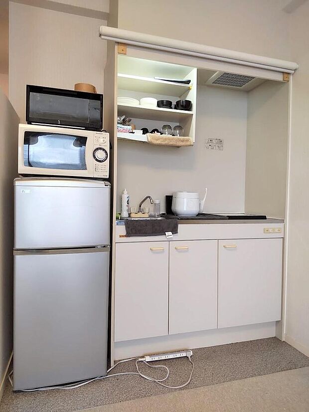 冷蔵庫とシンプルなキッチンスペース