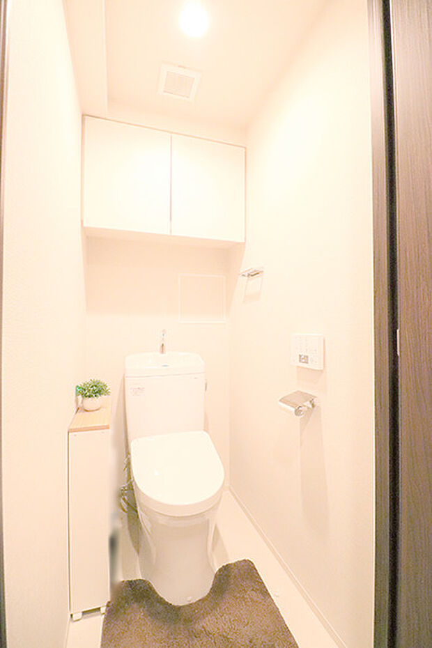 脱臭・オート洗浄機能を搭載したウォシュレットトイレ。上部の吊戸棚にはペーパー等を収納できて便利です。