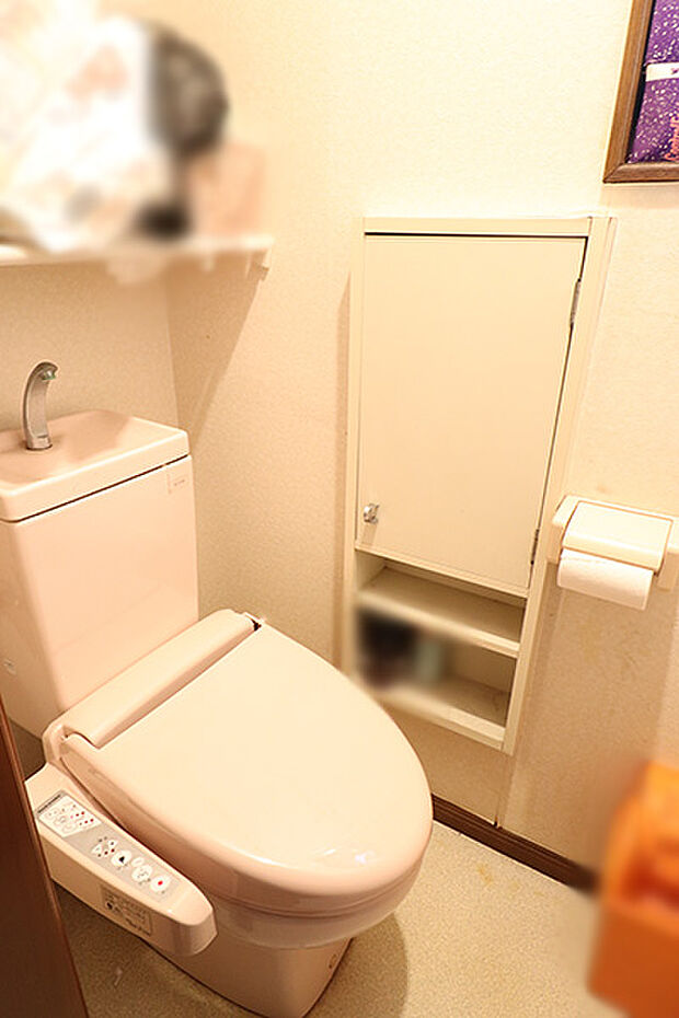 1階トイレは温水洗浄便座付。トイレットペーパーの予備も収納できる棚が設置されています。