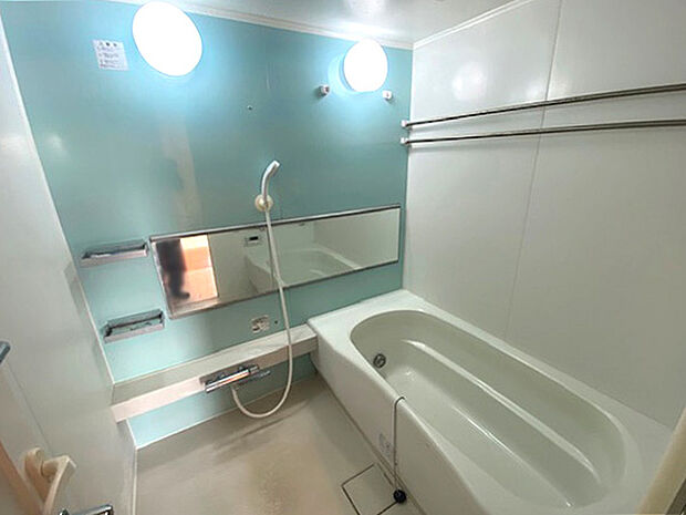 大型ワイドミラーを設置した清潔で機能的なゆったりサイズのバスルーム。