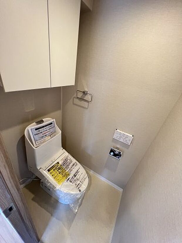 快適な温水洗浄便座付きのトイレ。上部の棚には、トイレットペーパーや掃除用品などが収納できます。