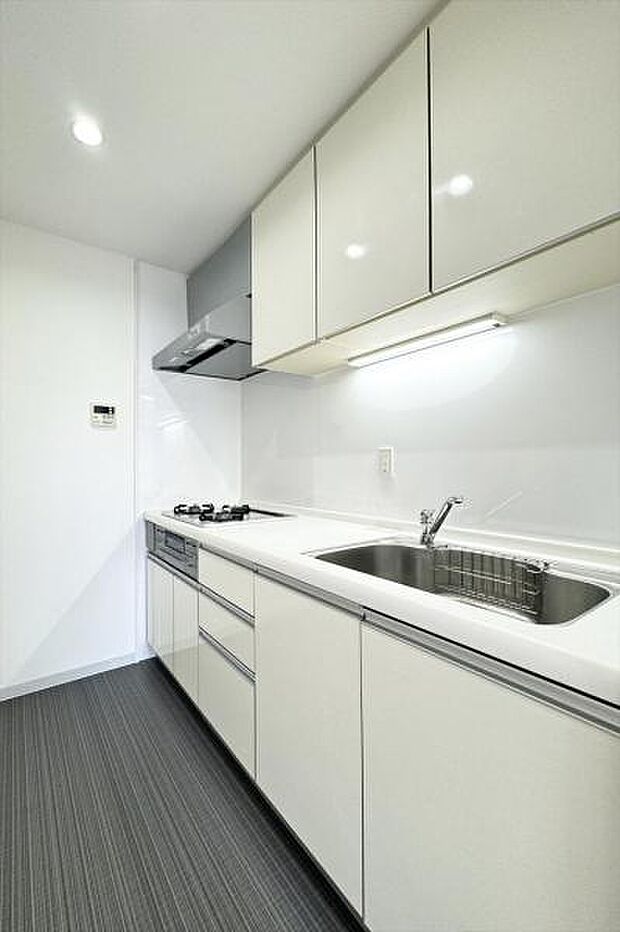 白を基調とした清潔感のあるキッチンは半独立型で生活感の出にくい配置です。