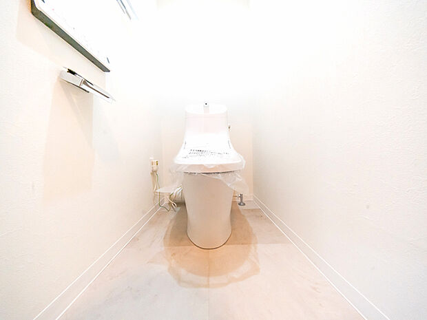 白を基調とした清潔感のある空間に設置されたトイレ。温水洗浄便座付のものに交換しました。
