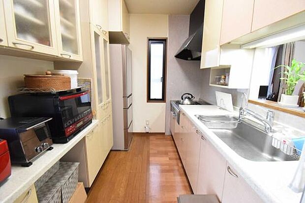 キッチン後部には、キッチン用品をスッキリ収納できるカップボード付き。吊り戸棚もあり収納力◎