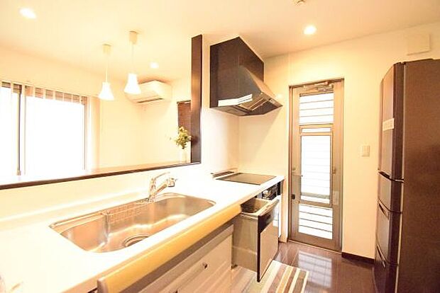 窓から光が差し込み手元も明るい対面式キッチン。IHクッキングヒーターのお掃除はサッと拭くだけ簡単。火が出ず安心な上、火力も十分で料理時間が短縮できます。