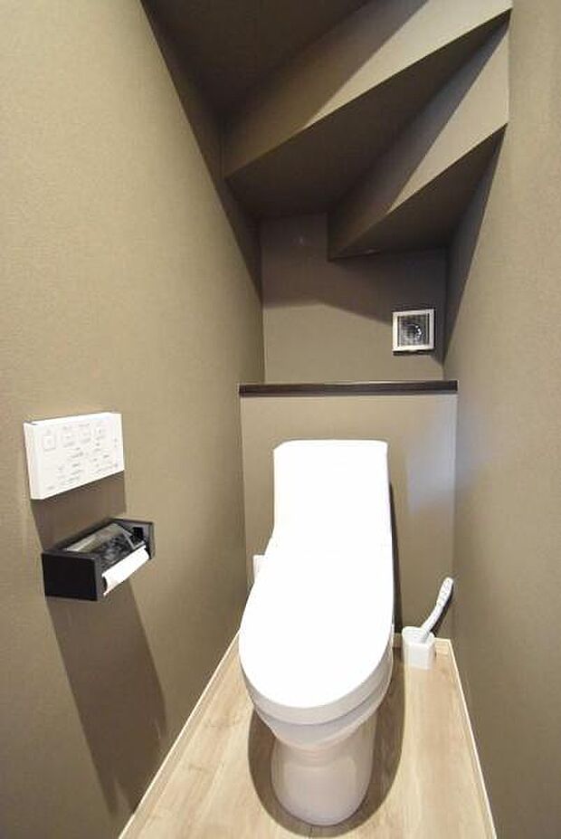 暗めな壁紙の中にある白いトイレは清潔感を感じさせます。後ろの棚には、緑や好きなものを置いても◎暗めのまま少し大人な雰囲気も◎