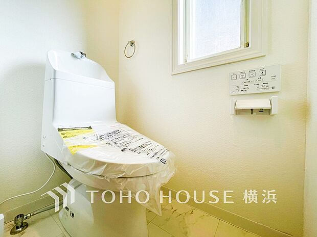 トイレはシンプルにホワイトで統一。多機能型の温水洗浄付き。