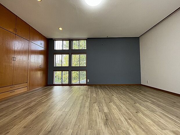 壁面の収納とアクセントクロス、そして機能美あふれる窓の配置を感じる居室空間。