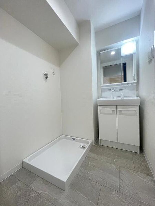 【洗面台・洗面所】ゆとりある広さの洗面脱衣室。洗面台と物置台と洗濯パンが設置されております。