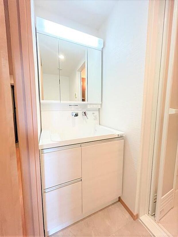 シャワー付き洗面化粧台　洗濯用水栓交換　防水パン設置　洗面化粧台はハウステック製。三面鏡の裏側はすべて収納になっています。洗面ボウルは底が平らなので、つけ置き洗いなどの家事でも活躍します。