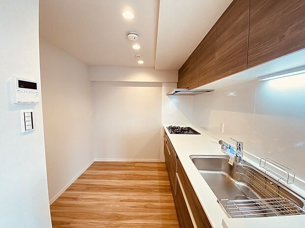 壁付のキッチンは上部に収納が作りやすいのがメリット。空間を有効活用したすっきりとしたデザイン。 