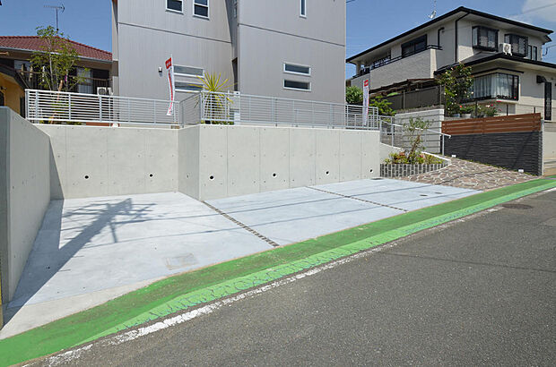 TBK塗装仕上げの打ちっ放し擁壁と、カラーコンクリート仕上の２台分の駐車スペース。