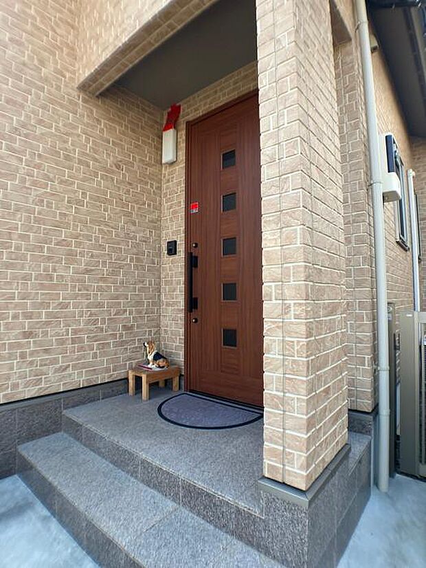 温かみのあるタイル調の外壁に、ブラウンの玄関ドアがオシャレですね♪