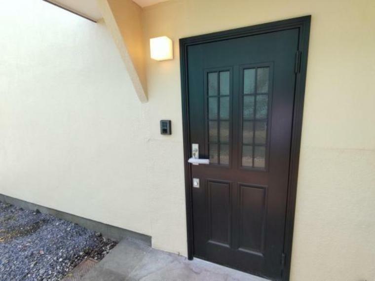 【リフォーム後写真】玄関は位置を変更して新設しました。既存のドアはリビングの土間に直接入れる入口として残しました。ドア新設、照明交換、インターホン設置で仕上げました。