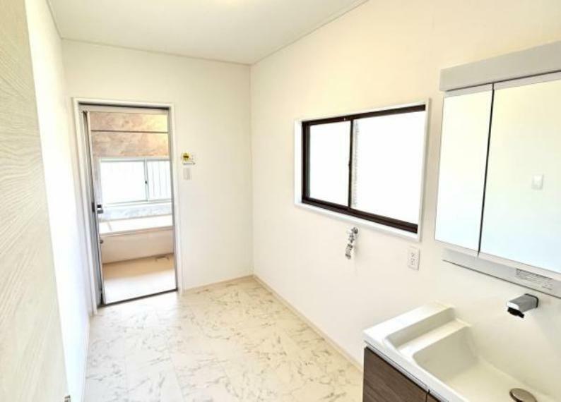 【リフォーム済】洗面所の写真です。奥が浴室になります。2坪のスペースがありますので、通常の洗面所より、広く使いやすいです。洗面台交換、床クッションフロアー貼り、壁・天井クロス貼替、照明交換を致しました。