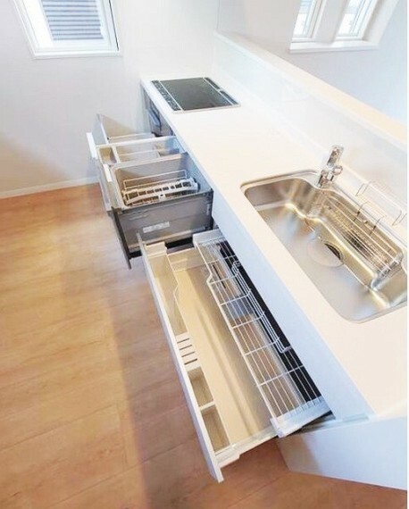 レンジ下やキッチンカウンターの下部には、調理器具や調味料などがすっぽり収まり、出し入れも簡単なスライド収納。