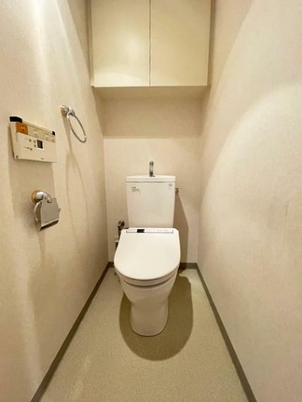 ウォシュレット機能付きトイレ。収納には便利な吊戸棚備え付け。