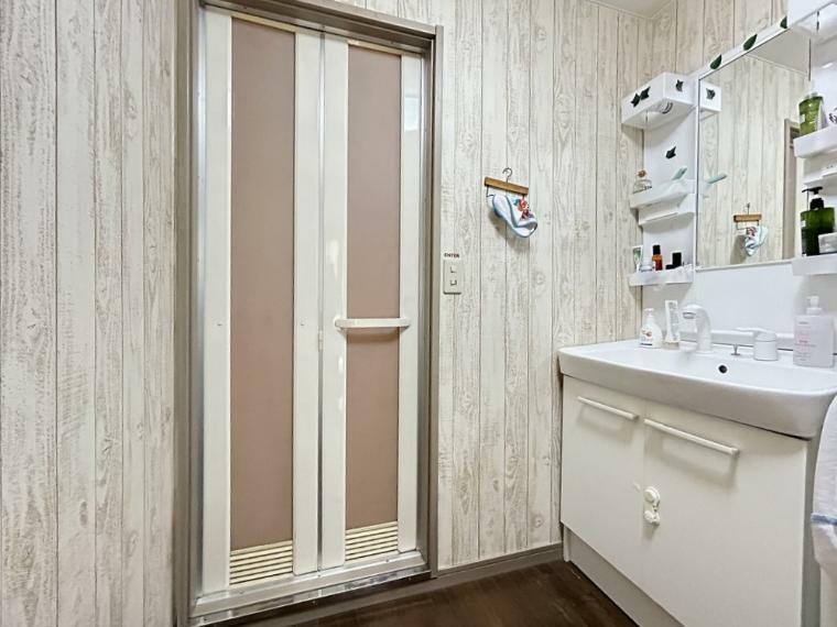 木目調の壁紙がかわいい洗面室です。隣には納戸もあるので、動線ばっちりです！