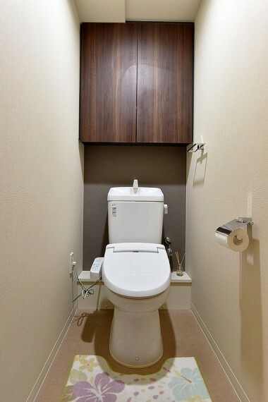 シックな雰囲気で落ち着きを感じる、シャワー機能付きのトイレです。上部に棚付きです。