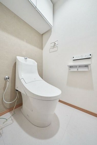 【トイレ】快適な温水洗浄便座付きトイレ。トイレットペーパーなどを収納出来る吊戸棚があります。
