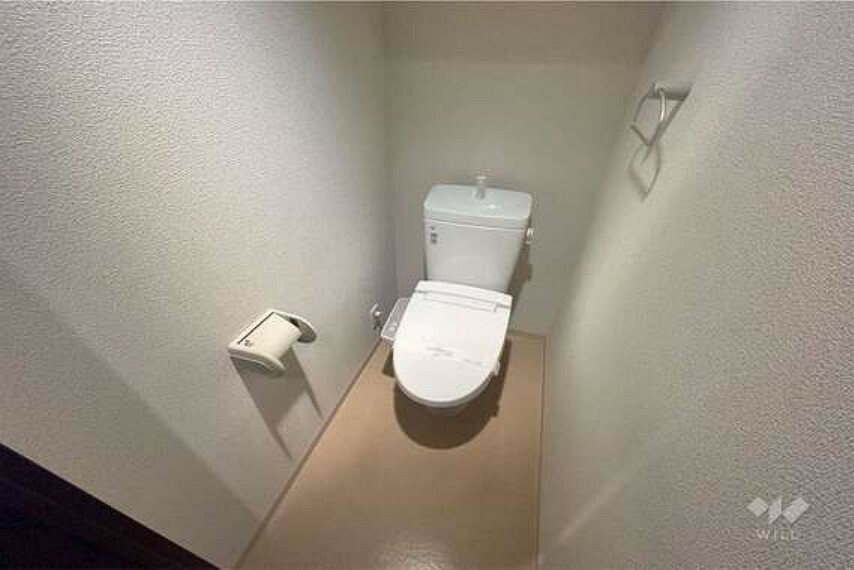 【トイレ】白基調の清潔感溢れる個室空間です。トイレットペーパーホルダーの上に携帯などを少し置くこともできます。