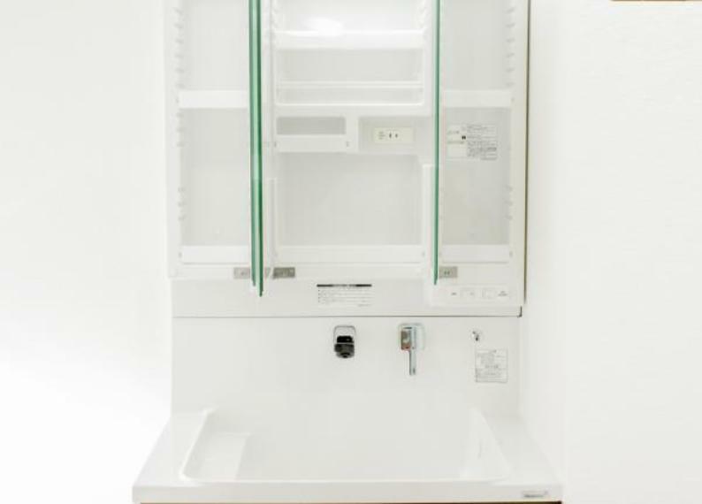 【同仕様写真】洗面台の鏡は三面鏡タイプで内部が収納棚になっています。収納の内部にコンセントがあるので電動歯ブラシや電気シェーバーなどは充電したまま収納することができます。