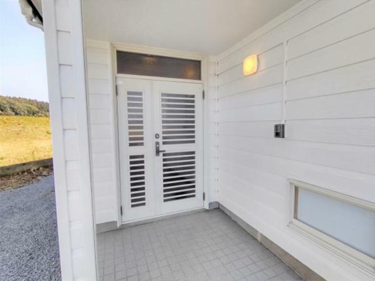 【リフォーム済】玄関です。洋風のドアタイプです。カギ交換とクリーニングを行いました。白を基調とした明るい玄関ですね。