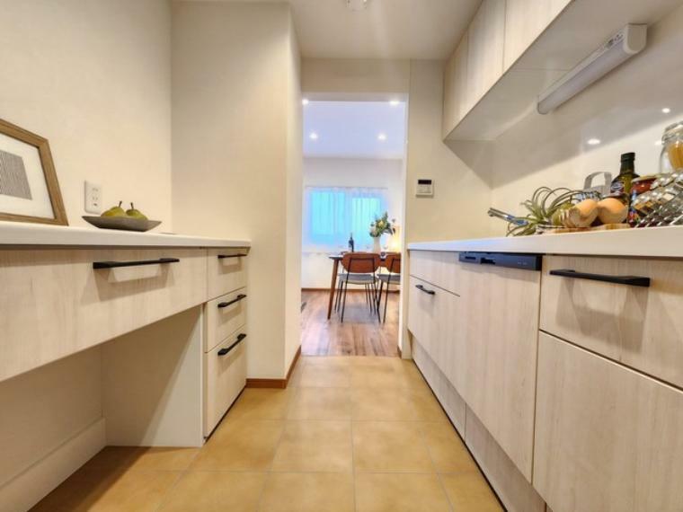 壁付のキッチンは上部に収納が作りやすいのがメリット。空間を有効活用したすっきりとしたデザイン。