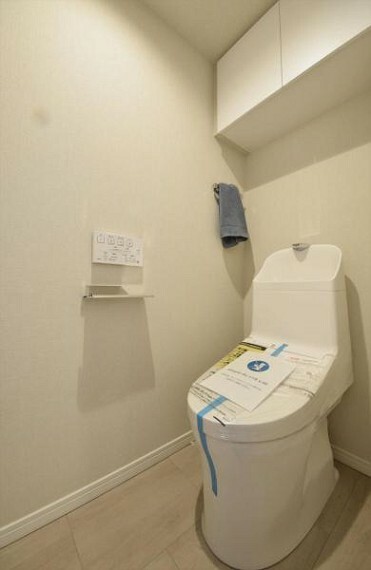 白を基調にした清潔感のあるトイレには、便利な吊戸棚を設置