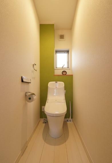 1階トイレ。黄緑色のアクセントクロスが貼られ優しい空間に仕上がっています