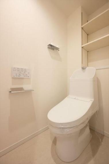 白を基調にした清潔感のあるトイレには、便利な棚板を設置