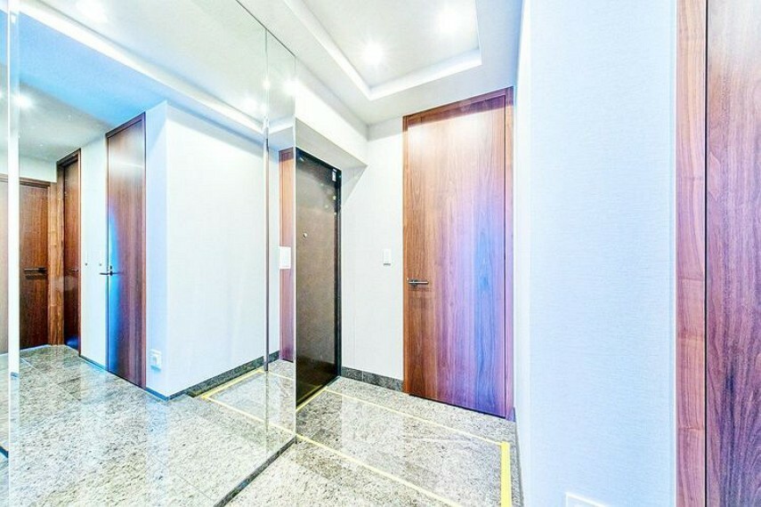 【玄関】床は高質感のある天然石を使用。住まう人を優しく迎え入れる包容力のある玄関ホール。