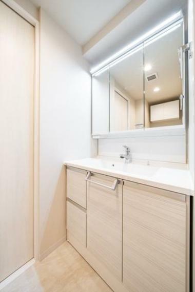清潔感のあるホワイトカラーでコーディネートした洗面室。身だしなみのチェックがしやすい大きな3面鏡。収納力も豊富で、スッキリとした空間です。