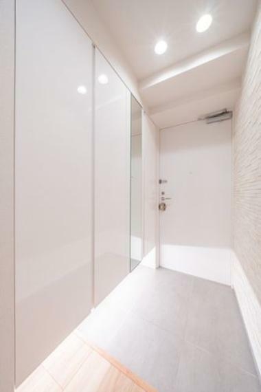 住まいの第一印象を決める玄関スペースにはホワイト鏡面の下駄箱（ミラー付）を設置し、高級感と清潔感を演出。