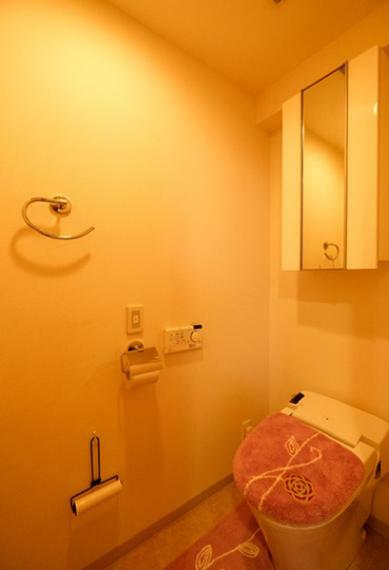 空間をすっきり見せる暖房便座や洗浄機能付きのタンクレストイレを採用。鏡付きの吊戸棚も設けてあります。