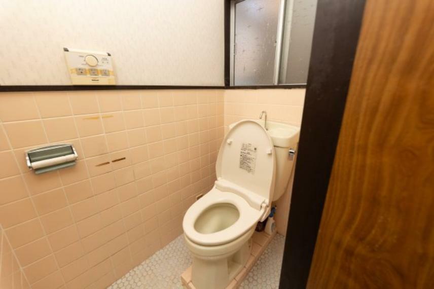 シンプルで衛生的な白とピンクを基調としたトイレです。換気も出来る窓があります。壁は掃除のしやすいタイルなので、清潔で快適なトイレ空間を保つことが出来ます。こちらは洗面所から出入り出来ます。